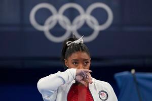 Simone Biles, de Estados Unidos, observa a las gimnastas actuar después de una aparente lesión, en los Juegos Olímpicos de Verano de 2020, el martes 27 de julio de 2021, en Tokio. Biles se retiró de la final por equipos. (Foto AP / Ashley Landis)