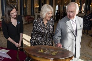 El rey Carlos III de Gran Bretaña y la reina Camilla ven parte de la Colección Real relacionada con la conexión de la familia real con Kenia, durante una recepción para la diáspora keniana en el Reino Unido en el Palacio de Buckingham, en el centro de Londres, el 24 de octubre de 2023.   (Aaron Chown/Pool vía AP, archivo)