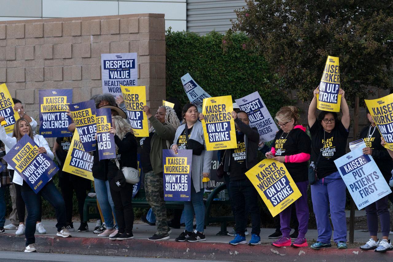 Los trabajadores de Kaiser Permanente llevan carteles de protesta afuera del hospital durante una huelga en la sección Panorama City de Los Ángeles el miércoles 4 de octubre de 2023.