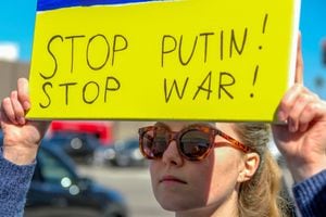 En Lo Ángeles (California, Estados Unidos), una manifestante a favor de Ucrania sostiene un letrero que le pide a Vladimir Putin, presidente de Rusia, detener "la guerra". 24 de febrero de 2022. Foto: Reuters/Ringo Chiu