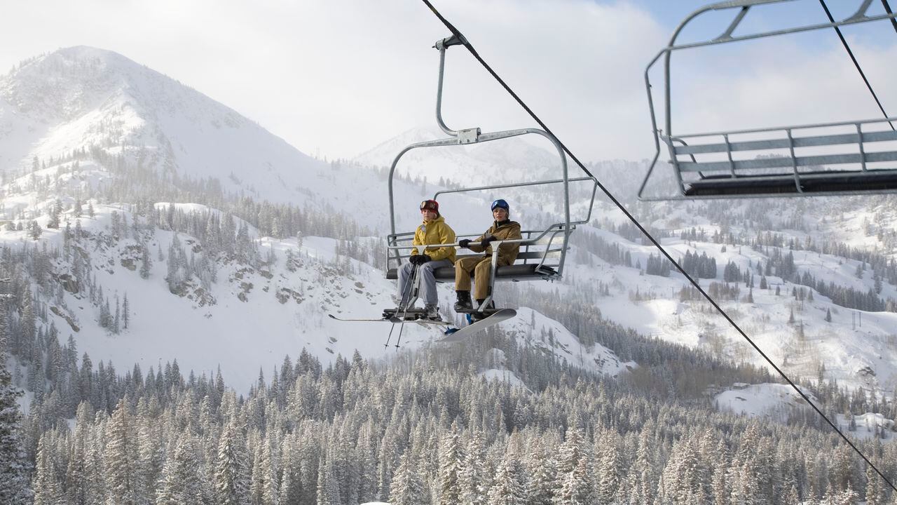 USA, Utah, teenage girl and boy (13-16) sitting on ski lift at Brighton ski resort