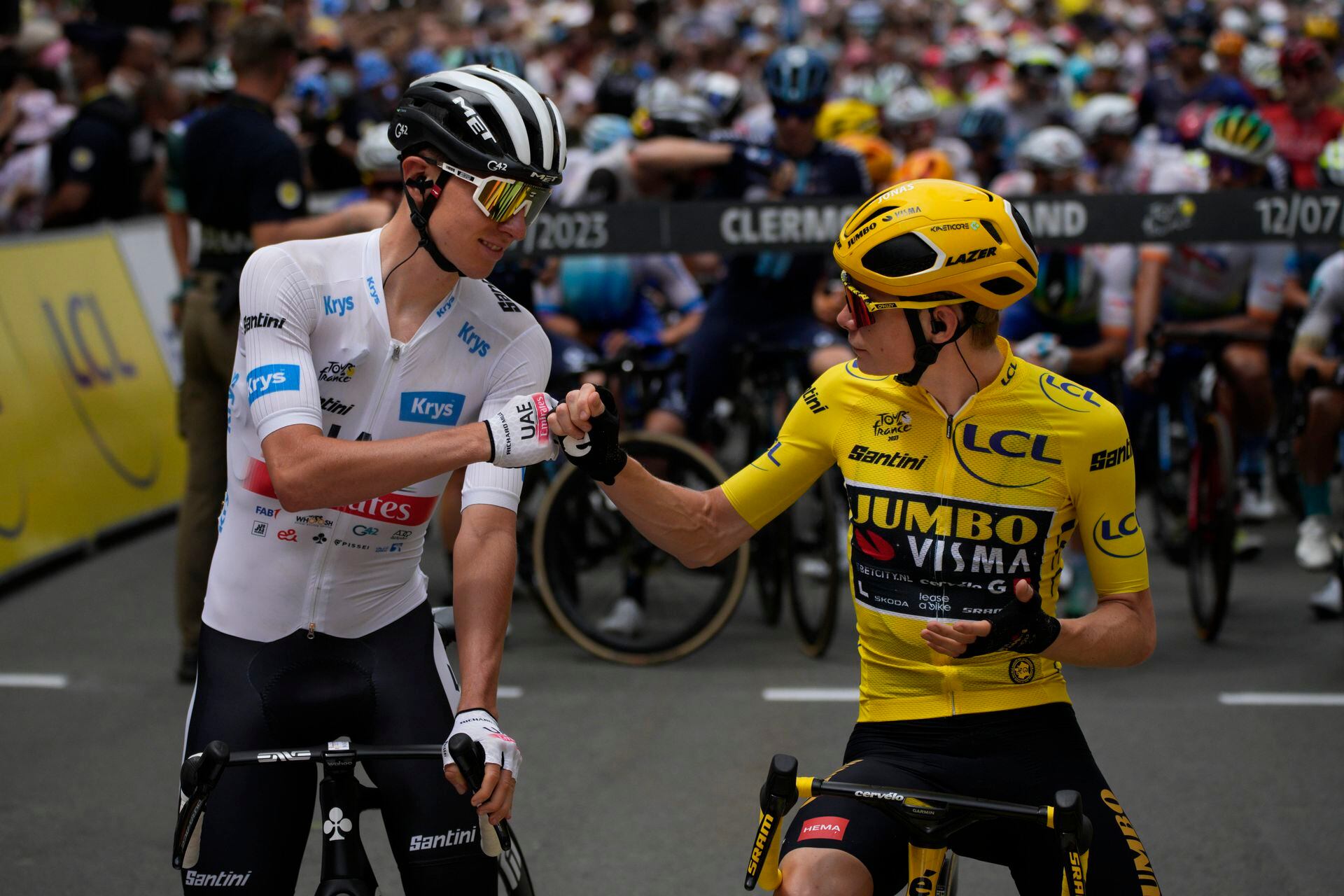 Slovenia's Tadej Pogacar, in young rider's best white jersey, and Dane Jonas Vingegaard, in overall leader's yellow jersey, pump up their fists before stage 11 of the Tour de France, a race of over 180 kilometers (112 miles) with a start in Clermont-Ferrand and a finish in Molines, France, Wednesday, July 12, 2023 (AP Photo/Daniel Cole)