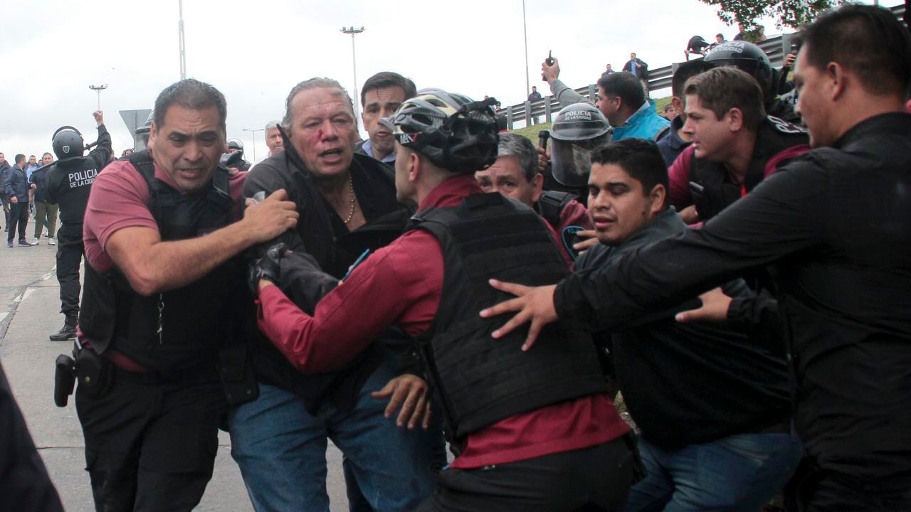Policía intenta evacuar a Sergio Berni, ministro de Seguridad de la provincia de Buenos Aires, atacado por manifestantes.