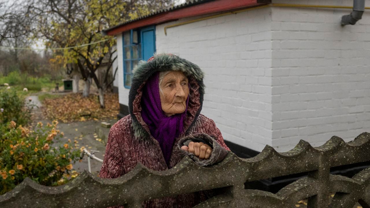 Una anciana ucraniana mira desde su jardín en el pueblo de Bilozerka, cerca de Jersón, en medio de la invasión rusa de Ucrania. (Foto de BULENT KILIC / AFP)