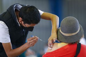 Un trabajador médico le inyecta a una mujer una dosis de la vacuna rusa Sputnik V contra el COVID-19 el miércoles 24 de febrero de 2021, en el Palacio de los Deportes, distrito de Iztacalco, en la Ciudad de México. (AP Foto/Rebecca Blackwell)