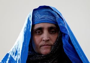 FILE PHOTO: FILE PHOTO: Sharbat Gula, the green-eyed "Afghan Girl" whose 1985 photo in National Geographic became a symbol of her country's wars, arrives to meet with Afghanistan's President Ashraf Ghani in Kabul, Afghanistan November 9, 2016. REUTERS/Stringer/File Photo/File Photo