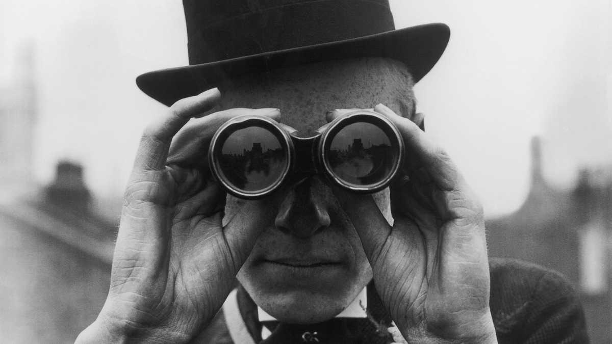 A spectator looking through binoculars at the Derby horse races, Epsom, Surrey, June 1923.  (Photo by Topical Press Agency/Hulton Archive/Getty Images)
