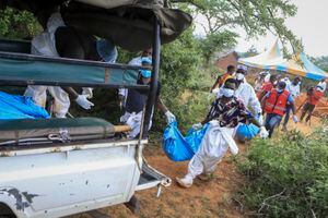 La policía y habitantes locales llevan cuerpos exhumados a un camión en la aldea de  Shakahola, cerca de Malindi, Kenia, el 23 de abril de 2023.