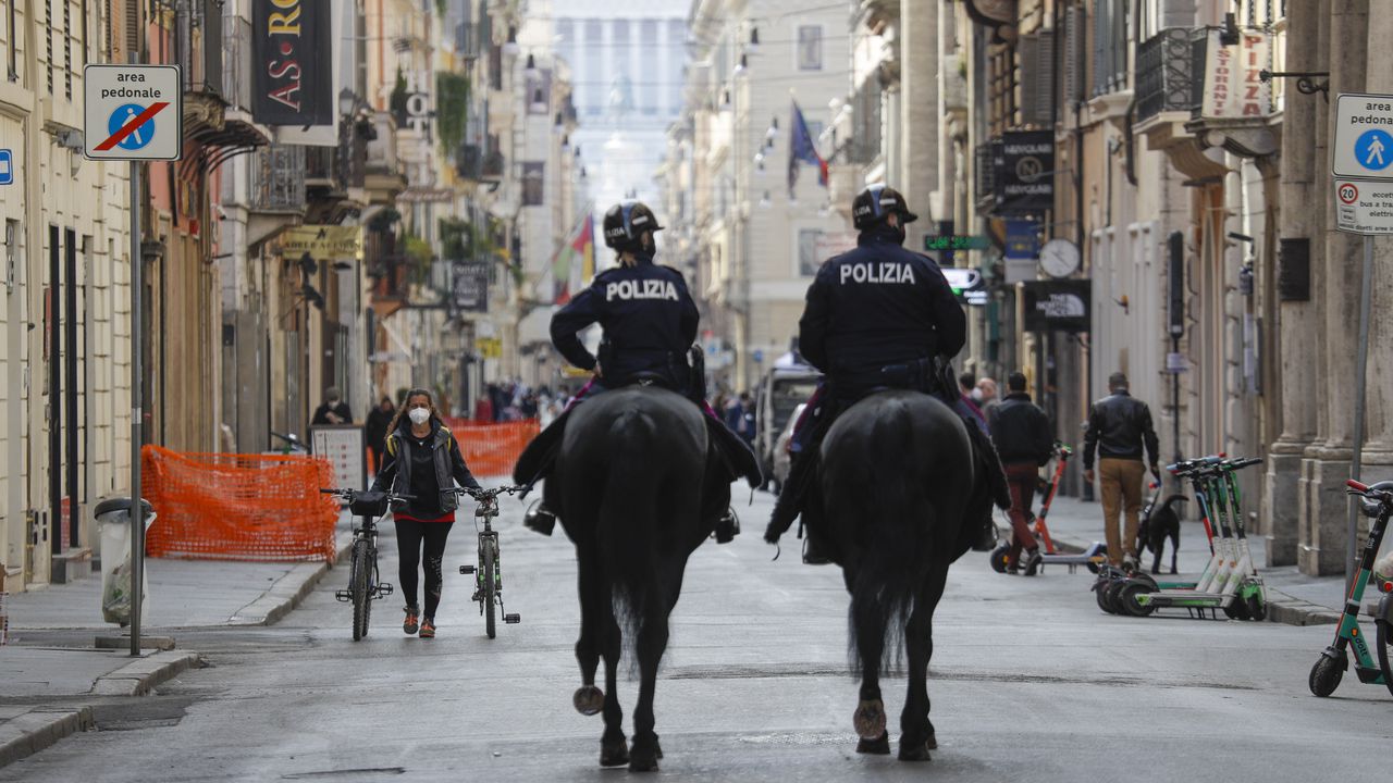 Los "carabinieri" en la Via del Corso en Roma. La fuerza aumentó su pie de fuerza para controlar el cumplimiento de las medidas para estos días festivos.