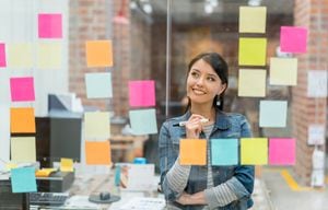 Mujer latinoamericana pensando en ideas creativas de ventas en la oficina para poner en un gráfico de pared