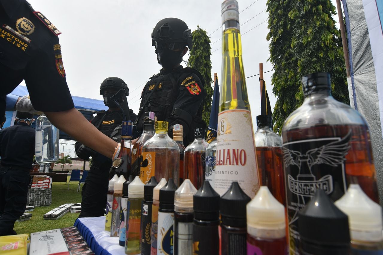 Los agentes destruyen bebidas alcohólicas que no están equipadas con sellos oficiales de impuestos especiales en la Oficina de Servicio y Supervisión de Aduanas de Pantoloan (KPPBC) en Palu, provincia de Sulawesi Central, Indonesia