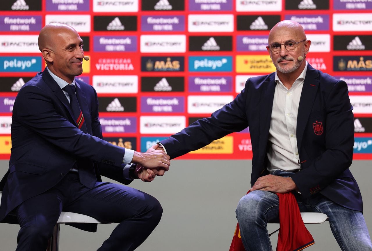 (FILES) Spain's national football team newly appointed head coach Luis de la Fuente (R) shakes hand with the President of the Spanish Football federation Luis Rubiales at the end of his official presentation to the press in Las Rozas, outside Madrid, on December 12, 2022. Spain's men's coach Luis de la Fuente criticised Spanish football federation chief Luis Rubiales' behaviour as "wrong" on August 26, 2023 after his unsolicited kiss on the lips of Women's World Cup star Jenni Hermoso. (Photo by Thomas COEX / AFP)