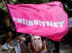 Un simpatizante de Britney Spears ondea una bandera con el lema #FreeBritney afuera de la corte durante una audiencia sobre la curaduría que controla la vida y finanzas de la estrella pop, el miércoles 23 de junio de 2021 en Los Ángeles. (AP Foto/Chris Pizzello)