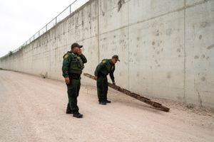 FILE - U.S. Border Patrol agents pick up a ladder that migrants carried to the border wall near the port of entry in Hidalgo, Texas, Thursday, May 4, 2023. A recent surge of migrants in the Brownsville area of the U.S.-Mexico border is highlighting immigration challenges as the U.S. prepares for the end of a policy linked to the coronavirus pandemic that allowed it to quickly expel many migrants. (AP Photo/Veronica G. Cardenas, File)