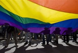 Manifestantes sostienen una bandera portando una bandera durante el Día del Orgullo Gay. el domingo en Bogotá.