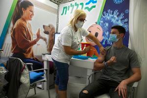 An Israeli youth receives a Pfizer-BioNTech COVID-19 vaccine during an event to encourage the vaccination of young Israelis at a vaccination center in the Israeli city of Holon near Tel Aviv, Monday, Feb. 15, 2021. (AP Photo/Sebastian Scheiner)