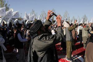 Los miembros talibanes toman fotografías con sus teléfonos móviles durante la ceremonia de izamiento de la bandera talibán en Kabul, Afganistán. Foto REUTERS/Ali Khara
