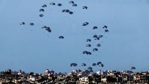 Paquetes caen hacia el norte de Gaza, después de ser lanzados desde un avión militar, en medio del conflicto en curso entre Israel y el grupo palestino Hamas, visto desde la frontera de Israel con Gaza en el sur de Israel el 7 de marzo de 2024.
