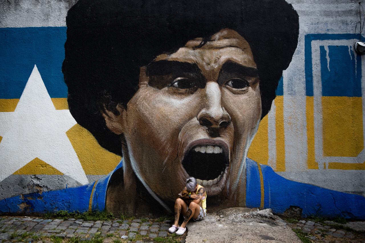 Mujer llora la muerte de Diego Armando Maradona frent a uno de sus murales
