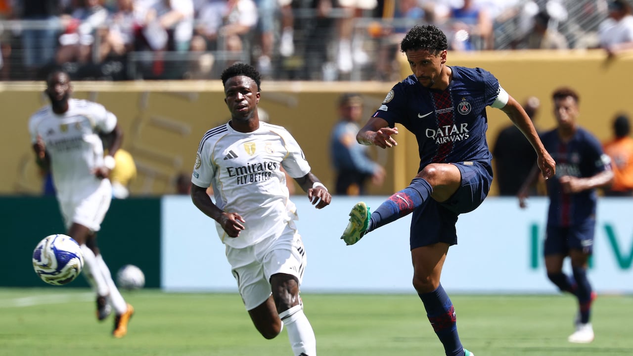 El defensa brasileño #05 del Paris Saint-Germain Marquinhos patea el balón junto al delantero brasileño #07 del Real Madrid Vinicius Junior.