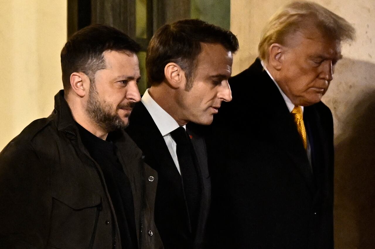 El presidente de Francia, Emmanuel Macron (centro), camina con el presidente electo de Estados Unidos, Donald Trump (derecha) y el presidente de Ucrania, Volodymyr Zelensky (izquierda), después de una reunión en el Palacio Presidencial del Elíseo en París el 7 de diciembre de 2024. Trump realiza su primer viaje internacional desde su victoria electoral, preparándose para un día de intensa diplomacia antes de asistir a la ceremonia de reapertura de la catedral de Notre Dame restaurada después del incendio de 2019. (Foto de JULIEN DE ROSA / AFP)