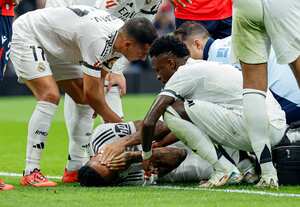 Eder Militao es atendido por sus compañeros de equipo, tras la lesión.