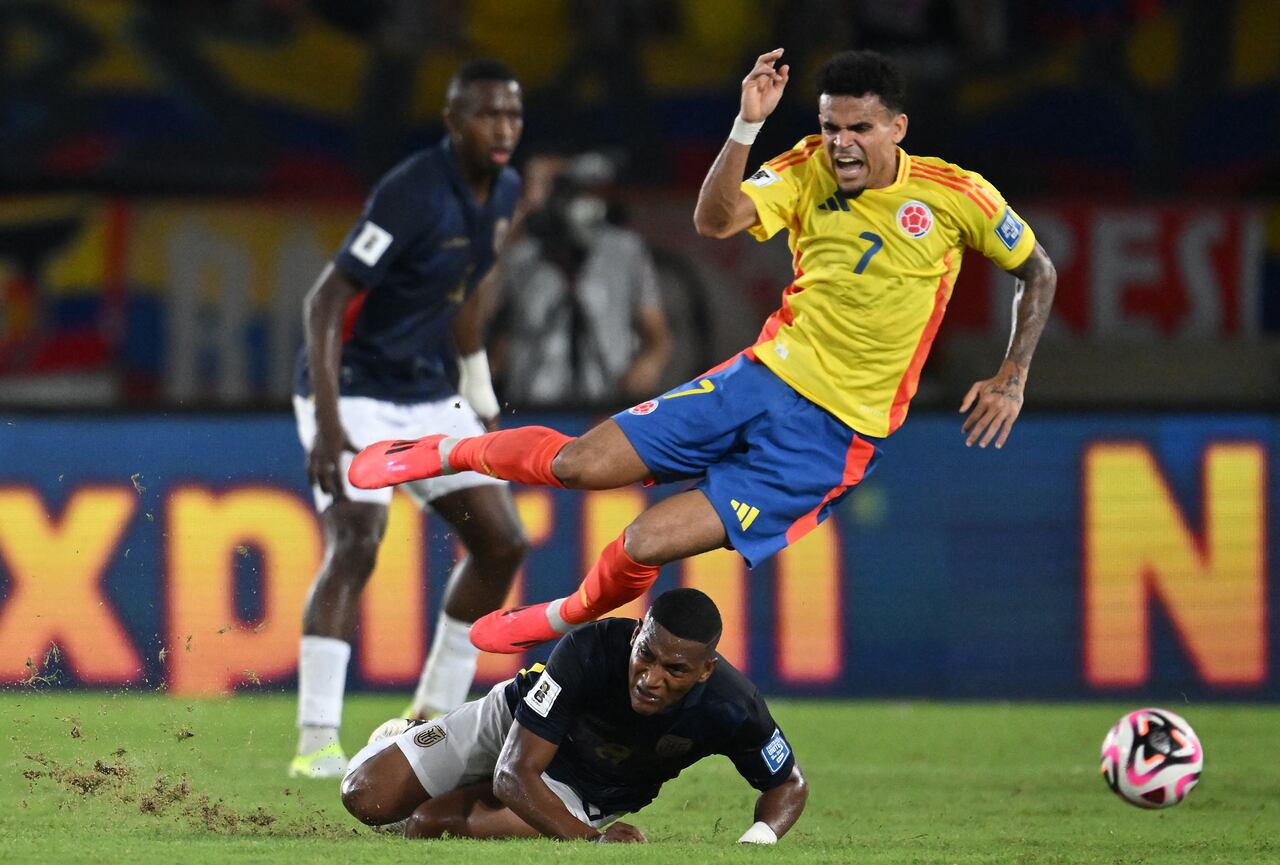 El delantero colombiano #07 Luis Díaz cae sobre el mediocampista ecuatoriano #08 Carlos Gruezo durante las eliminatorias sudamericanas para la Copa Mundial de la FIFA 2026.