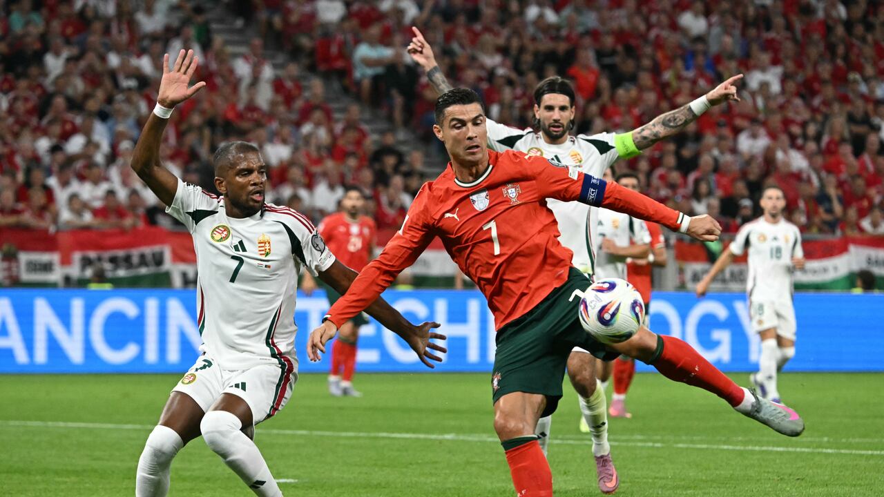 El delantero portugués Cristiano Ronaldo (centro) y el defensa húngaro Loic Nego (izq.) disputan el balón durante el partido de clasificación para el Mundial 2026, grupo F de la zona Europa, entre Hungría y Portugal, el 9 de septiembre de 2025 en Budapest, Hungría. (Foto de Attila KISBENEDEK / AFP)