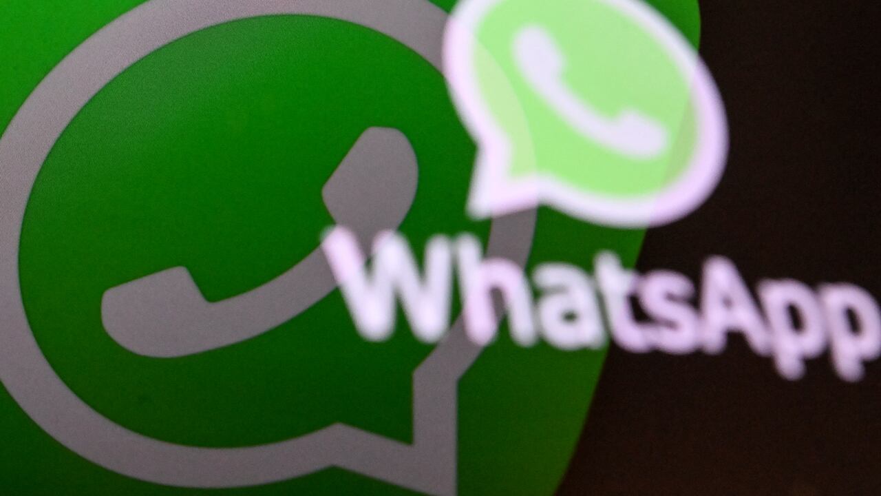 This photo illustration shows a woman checking the settings of the messaging application WhatsApp