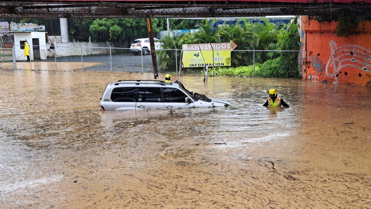El Cuerpo de Bomberos de Cali atendió tres casos de vehículos atrapados en zonas inundadas de la ciudad, como este bajo el puente de Chipichape. Las personas a bordo de estos carros salieron ilesas.