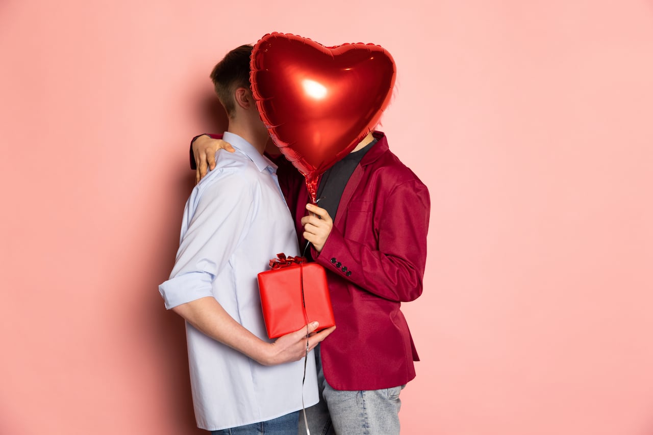 Gift, presents. Young couple holding balloons shaped hearts. Valentine's day celebration. Concept of emotions, facial expression, love, relations, same-sex marriage, rights, diversity, romantic