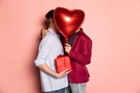 Gift, presents. Young couple holding balloons shaped hearts. Valentine's day celebration. Concept of emotions, facial expression, love, relations, same-sex marriage, rights, diversity, romantic
