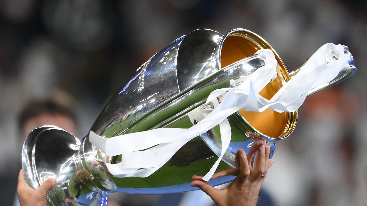 A Real Madrid team member holds the trophy after their victory in the UEFA Champions League final football match between Liverpool and Real Madrid at the Stade de France in Saint-Denis, north of Paris, on May 28, 2022. (Photo by FRANCK FIFE / AFP)