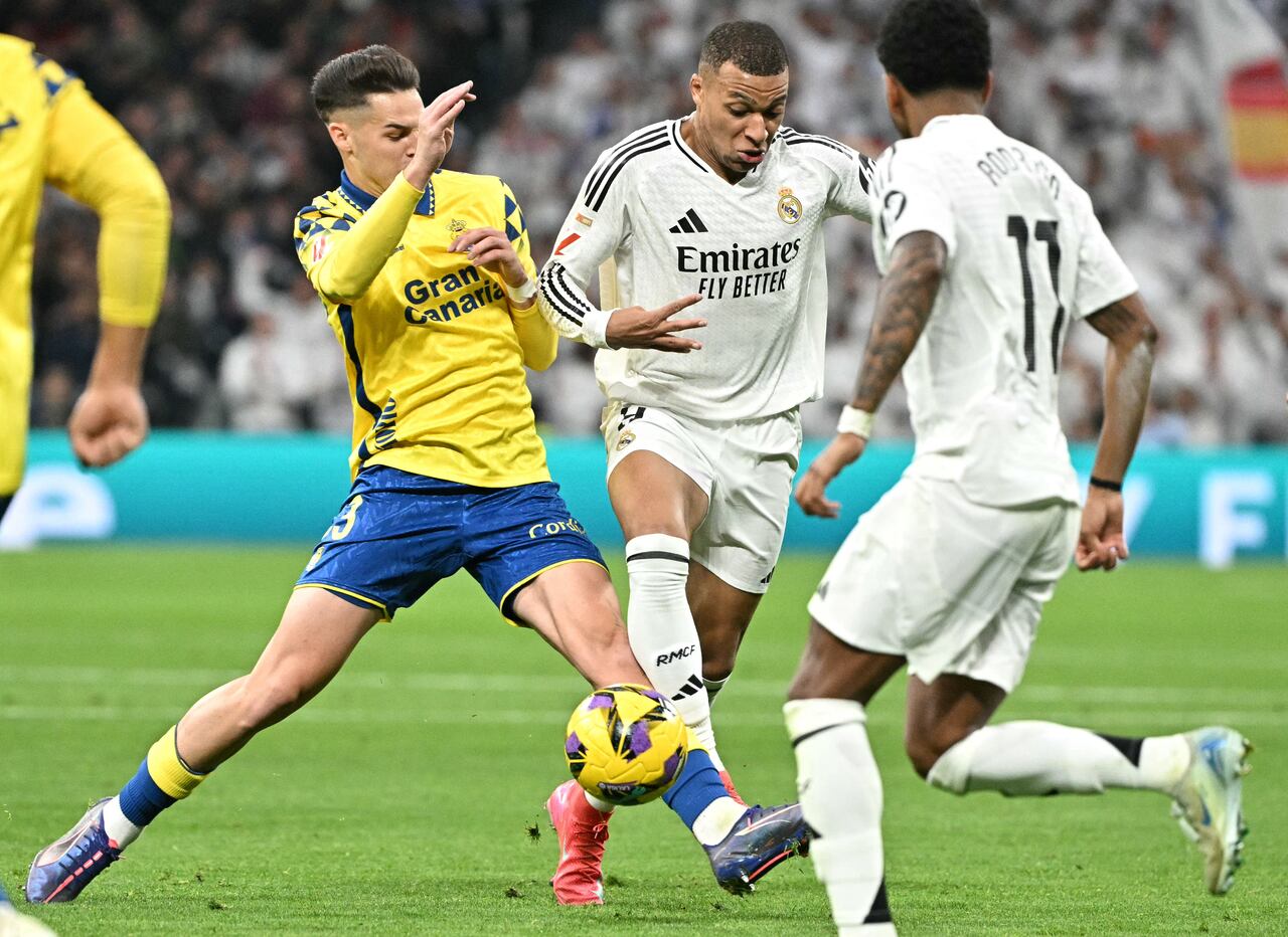El delantero francés del Real Madrid #09 Kylian Mbappé lucha por el balón con el defensor español de Las Palmas #03 Mika Marmol durante la liga española.