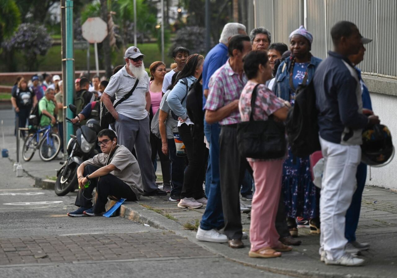 La gente hace cola frente a una farmacia para reclamar medicamentos en Cali, Colombia, el 25 de marzo de 2025 (Foto de JOAQUÍN SARMIENTO / AFP)