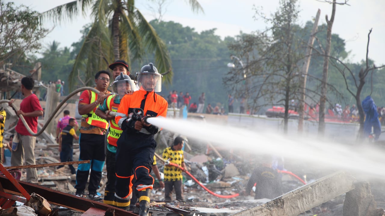 Un bombero rocía agua tras una explosión en un almacén pirotécnico en la provincia de Narathiwat, Tailandia, el sábado 29 de julio de 2023. (AP Foto/Kriya Tehtani)