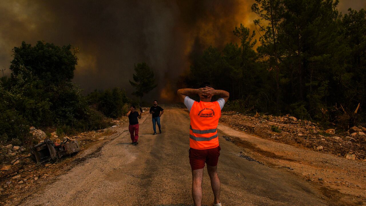 La gente huye de la aldea de Sirtkoy devastada por el fuego, cerca de Manavgat, Antalya, Turquía, el domingo 1 de agosto de 2021. Más de 100 incendios forestales han sido controlados en Turquía, según las autoridades. El ministro de Bosques tuiteó que continúan cinco incendios en los destinos turísticos de Antalya y Mugla. Foto: AP.