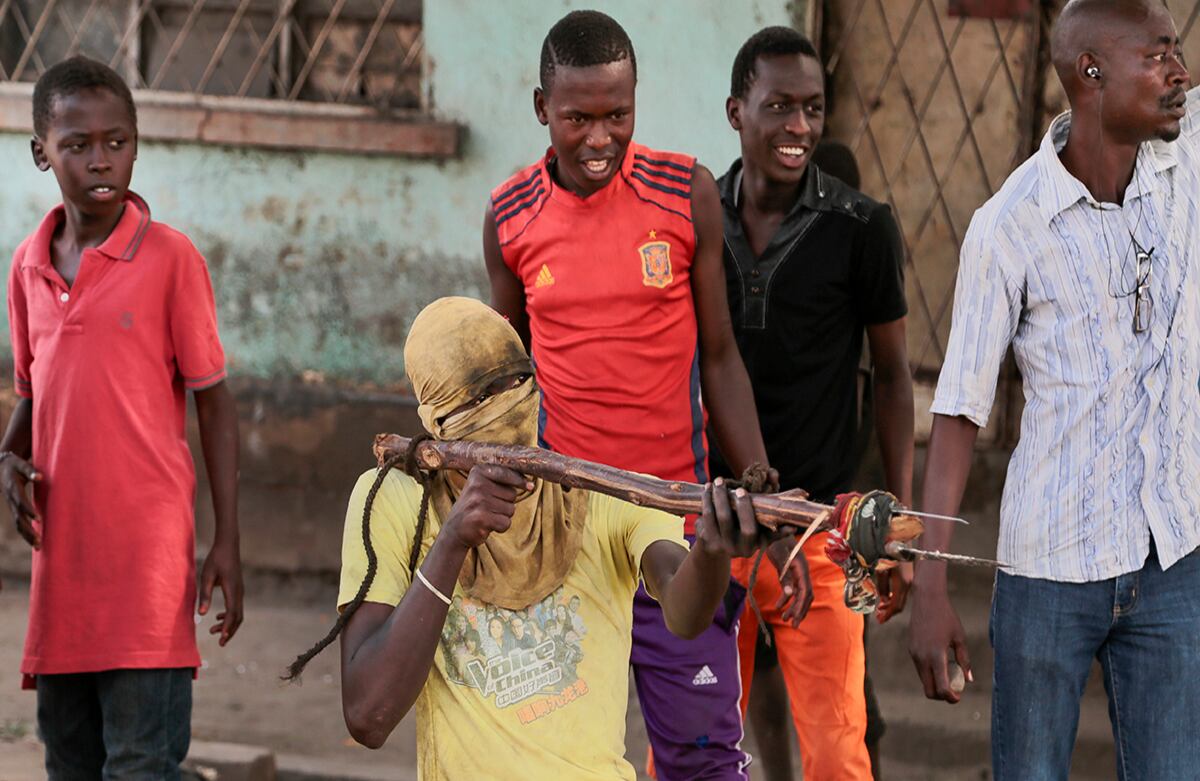Un manifestante apunta a un policía con un palo que tiene cuchillos atados, en Buyumbura, Burundi. Los protestantes exigen que el presidente, Pierre Nkurunziza, acabe con su mandato. (AP/Berthier Mugiraneza)
