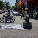 (FILES) In this file photo taken on August 26, 2019, dead body covered with a sheet lies on the middle of the road in downtown of Port-au-Prince. - Long confined to the slums, the gangs have gradually extended their control in Haiti and the nearly three million inhabitants of Port-au-Prince are forced to adapt their daily lives to this reality, for fear of being the next victim. "The gangs today reign supreme and lords over the country," laments G�d�on Jean, director of the Center for Analysis and Research in Human Rights, based in the Haitian capital. (Photo by CHANDAN KHANNA / AFP)