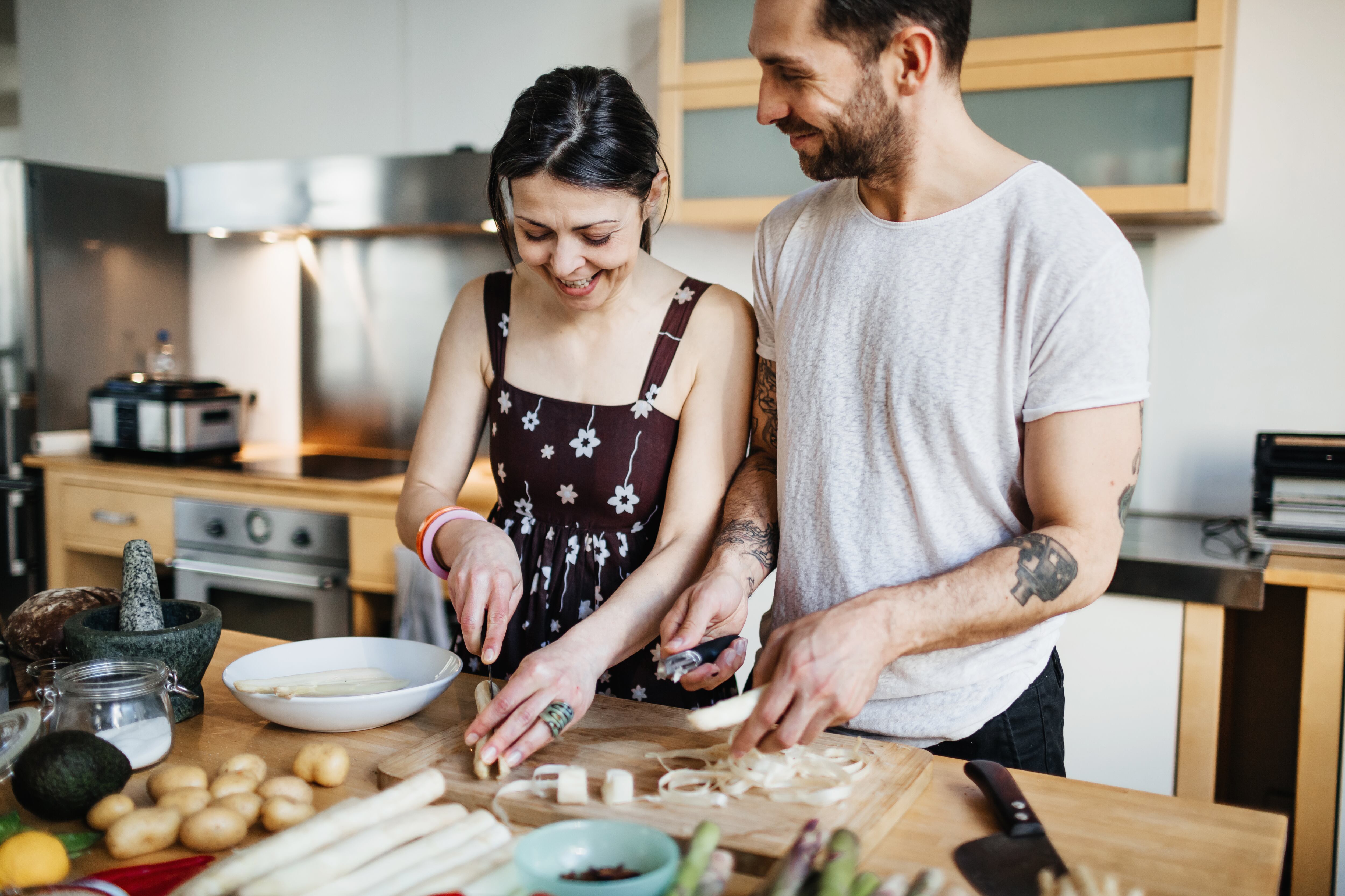Una pareja madura en su cocina preparando comida para una cena más tarde esta noche.