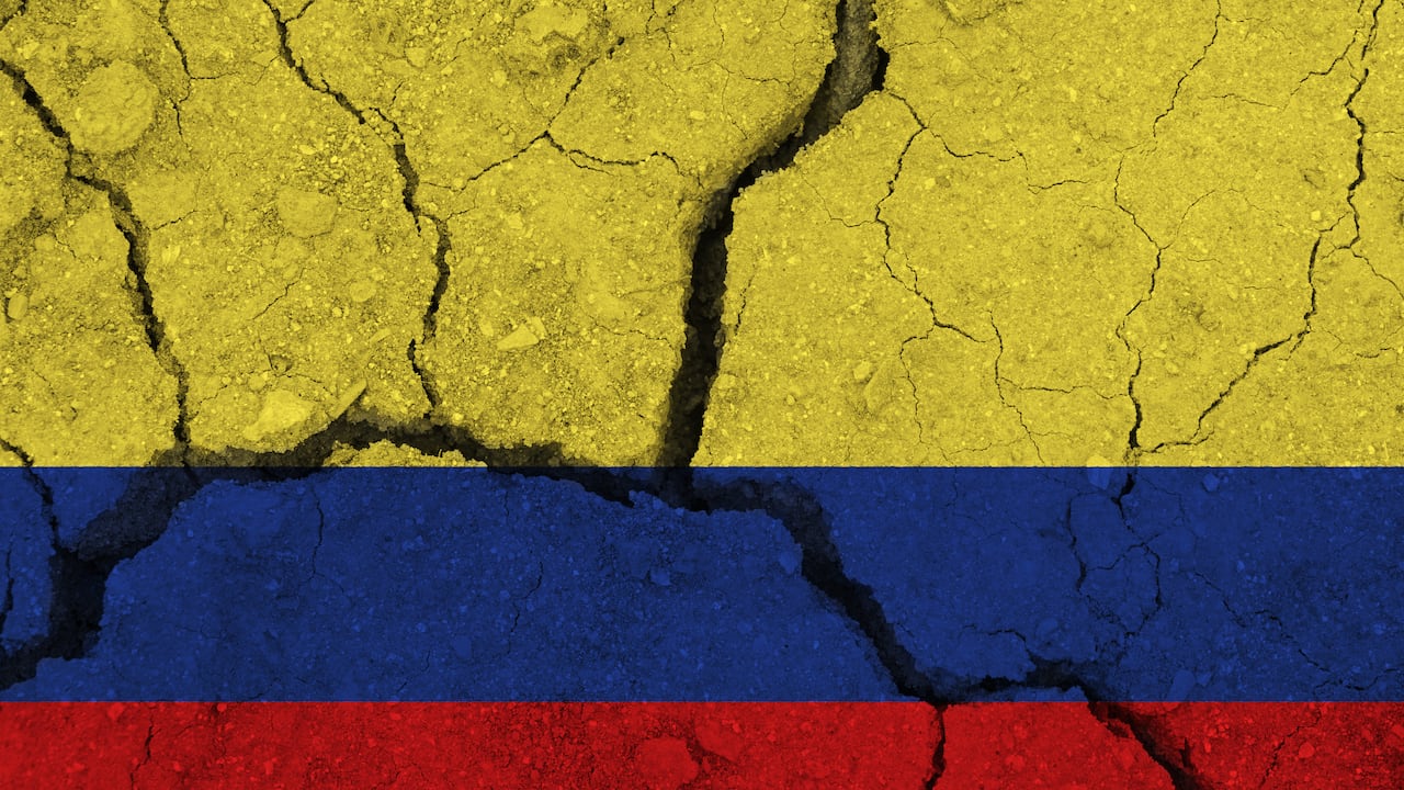 Colombia flag on the cracked earth. National flag of Colombia. Earthquake or drought concept