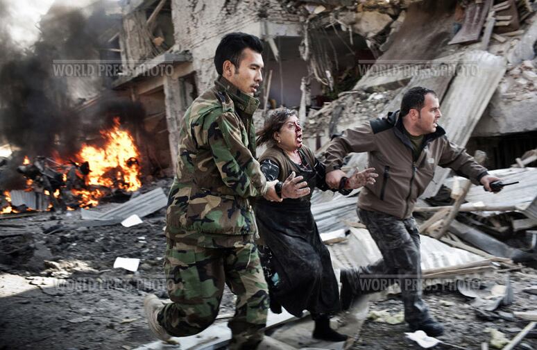 Una mujer afgana salió corriendo de la escena de un atentado suicida en Kabul, el 15 de diciembre.
