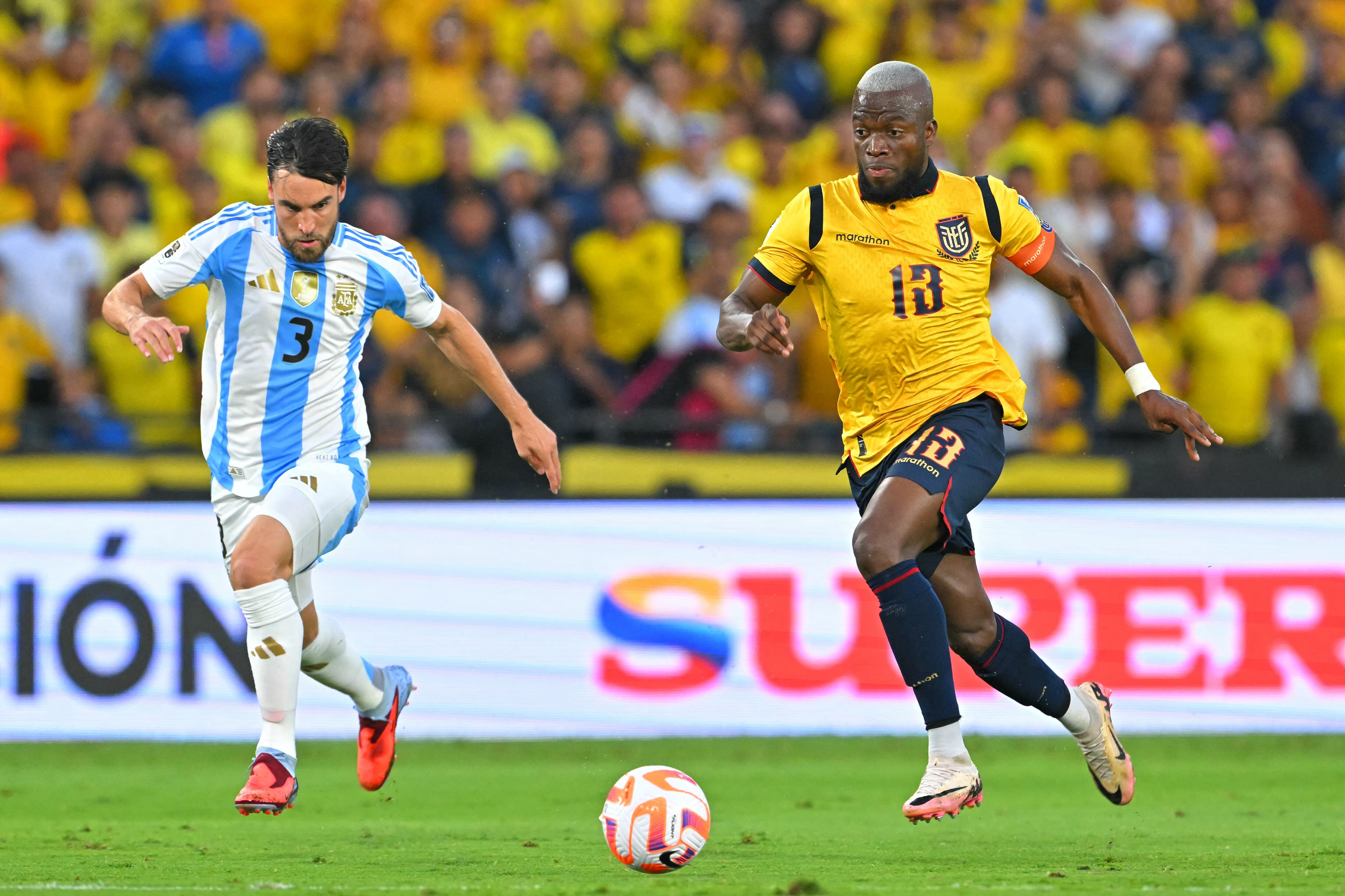 El defensa argentino #03 Nicolás Tagliafico y el delantero ecuatoriano #13 Enner Valencia disputan el balón durante el partido de clasificación sudamericana para la Copa Mundial de la FIFA 2026 entre Ecuador y Argentina en el Estadio Monumental Banco Pichincha en Guayaquil, Ecuador, el 9 de septiembre de 2025. (Foto de Rodrigo BUENDIA / AFP)