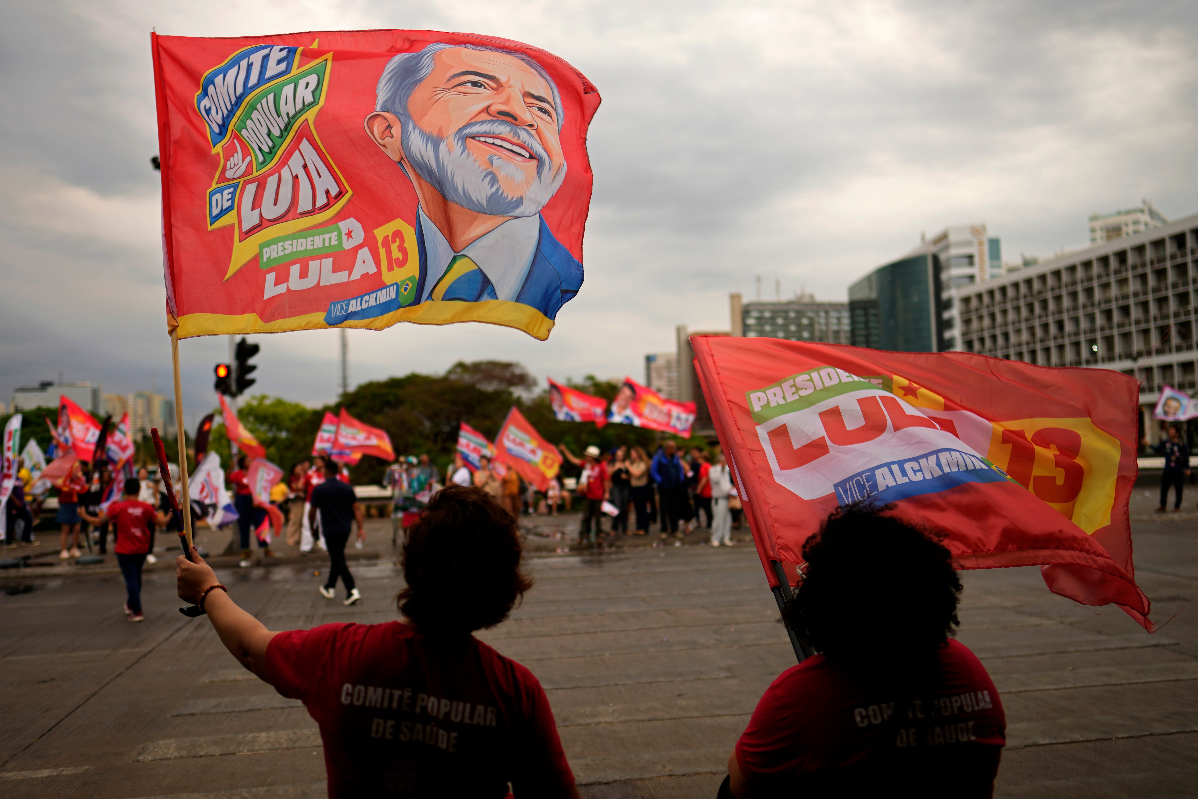 Partidarios del presidente brasileño Luiz Inácio Lula da Silva, quien busca la reelección, portan banderas de campaña durante un acto electoral en la estación central de autobuses de Brasilia, Brasil.