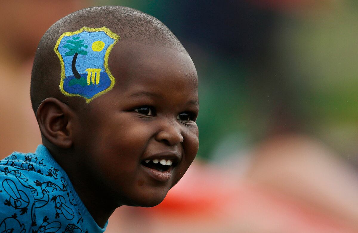 Un niño con el escudo de la Selección de críquet de Indias Occidentales pintado en su cara mira un partido entre las selecciones de Indias Occidentales y Sudáfrica. (AP)