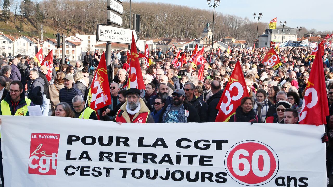 Los manifestantes sostienen una pancarta que dice "Para el sindicato CGT, la jubilación es siempre 60 años", durante una manifestación contra los planes para retrasar la edad de jubilación de Francia, en Bayona, suroeste de Francia, el jueves 16 de febrero de 2023. (AP Photo/Bob Edme)