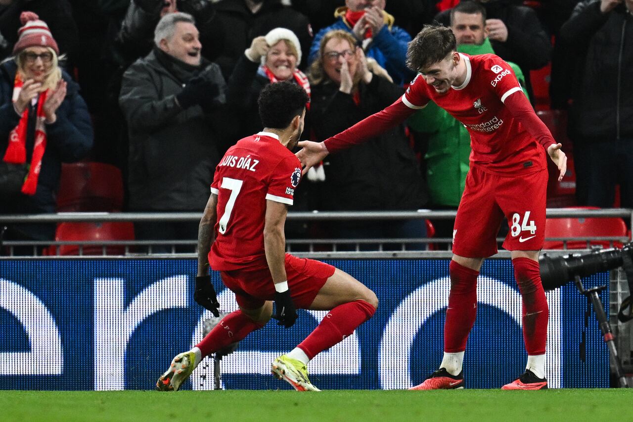 Liverpool's Northern Irish defender #84 Conor Bradley (R) celebrates with Liverpool's Colombian midfielder #07 Luis Diaz (L) after scoring his team second goal during the English Premier League football match between Liverpool and Chelsea at Anfield in Liverpool, north west England on January 31, 2024. (Photo by Paul ELLIS / AFP) / RESTRICTED TO EDITORIAL USE. No use with unauthorized audio, video, data, fixture lists, club/league logos or 'live' services. Online in-match use limited to 120 images. An additional 40 images may be used in extra time. No video emulation. Social media in-match use limited to 120 images. An additional 40 images may be used in extra time. No use in betting publications, games or single club/league/player publications. /