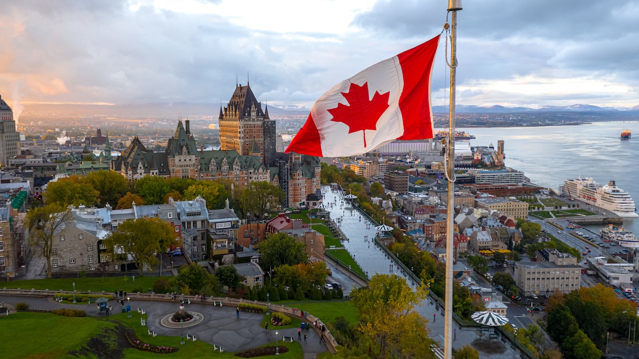 Una bandera canadiense en la ciudad de Quebec y el río San Lorenzo al fondo. Foto: Getty Images.