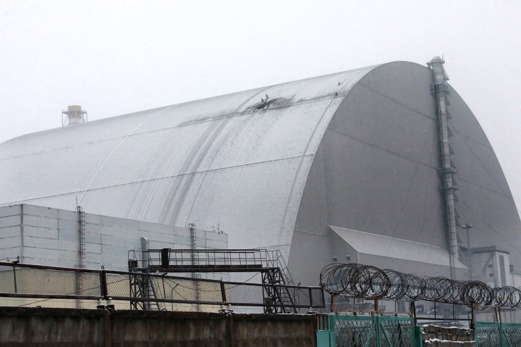 Los rescatistas trabajan en el lugar donde un dron de ataque ruso con una ojiva explosiva impacta el Nuevo Confinamiento Seguro en la Central Nuclear de Chernobyl en la región de Kiev, Ucrania, el 14 de enero de 2025. La estructura, instalada en 2016, protege los restos del Reactor 4 destruido durante el desastre de Chernobyl de 1986. (Foto de Volodymyr Tarasov/Ukrinform/NurPhoto) (Foto de Volodymyr Tarasov/NurPhoto vía AFP)