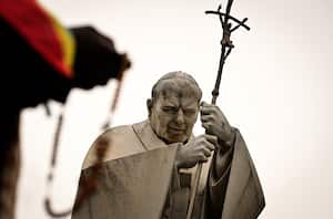 Fieles rezan el rosario a los pies de la imagen de Juan Pablo II, pidiendo por la salud del papa Francisco.
(Photo by Tiziana FABI / AFP)